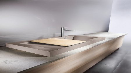 A Concrete sink in grey with a cutting board