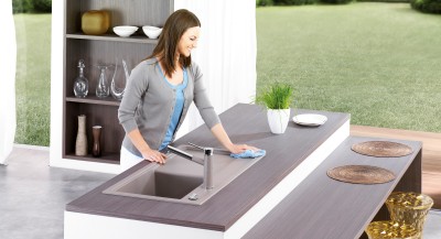 A woman cleans a stainless steel sink