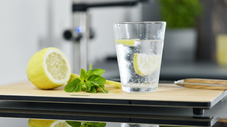 Glas Soda-Wasser mit Zitrone. Im Hintergrund Armatur BLANCO EVOL-S Pro Soda. 