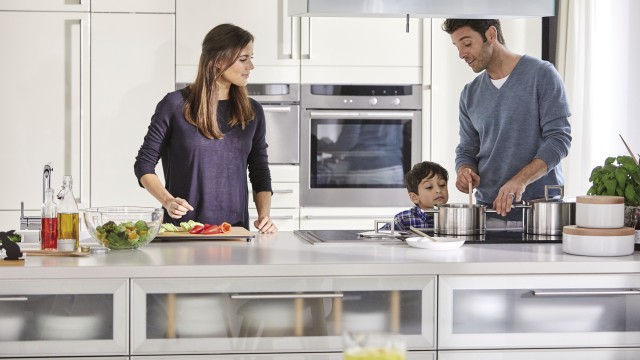 An einer großflächigen Kücheninsel macht gemeinsames Kochen mit der Familie noch mehr Spaß.