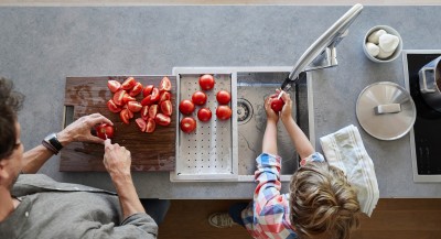 A father and his son are washing and cutting tomatos 
