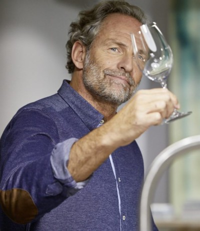 Ein Mann hält ein poliertes Weinglas in der Hand