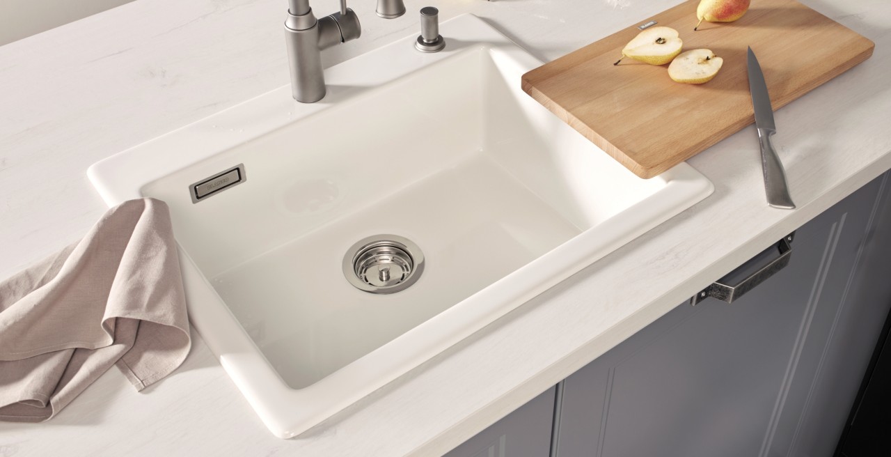 A white sink with a cutting board